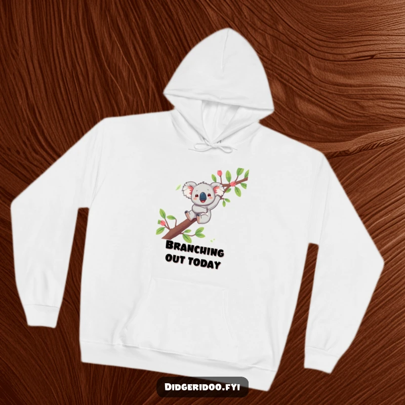 Funny koala hoodie featuring a playful character joyfully dangling from a eucalyptus branch, offering cozy Aussie relaxation.