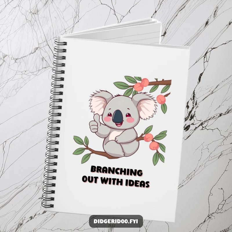 Funny, jovial koala character giving a thumbs up from a eucalyptus branch, featured on the cover of a notebook for writing and sketching.
