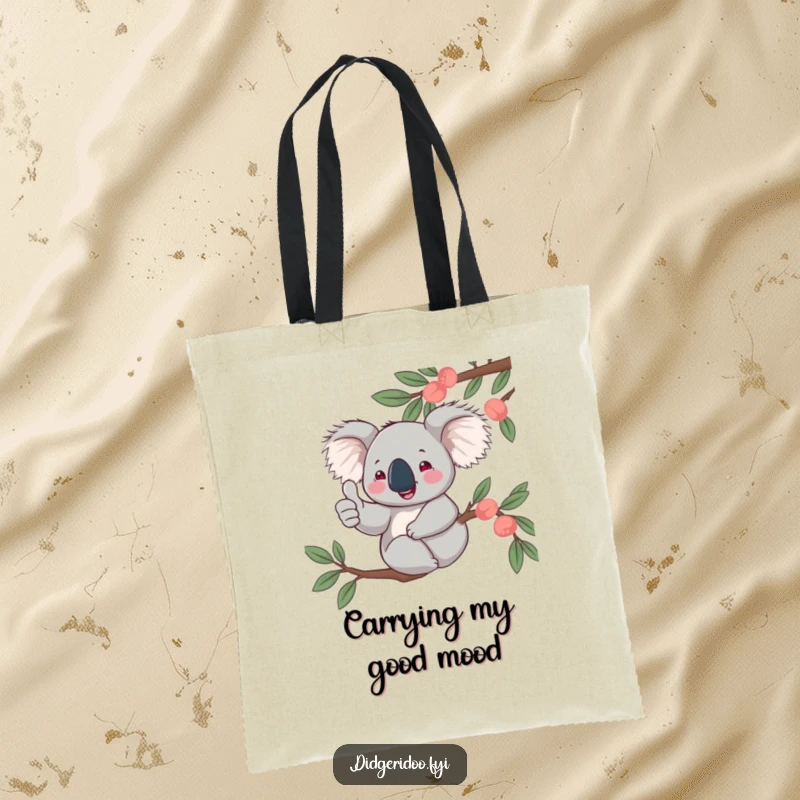 Funny, jovial koala character giving a thumbs up from a eucalyptus branch, pictured on a durable tote bag for stylishly cheerful carrying.